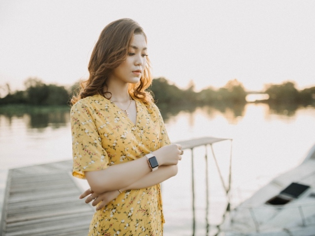 Красивая девушка азиатка стоит у реки 