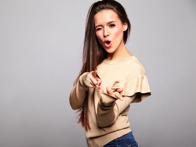 Яркая длинноволосая девушка на сером фоне 