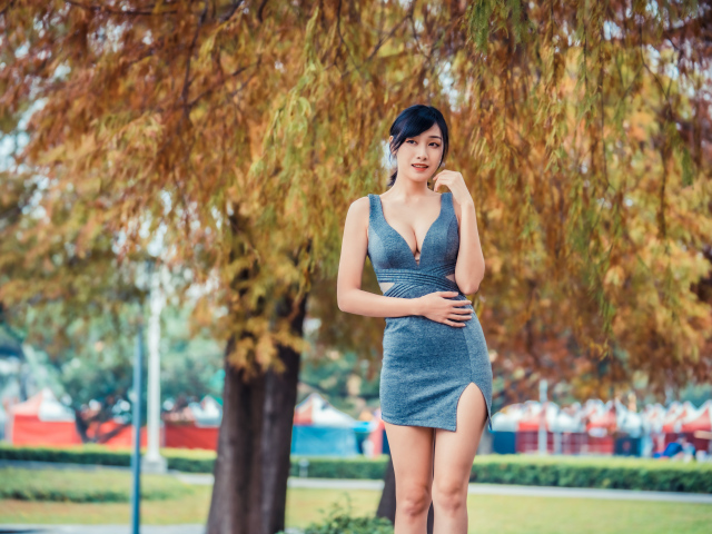 Девушка в сером коротком платье в осеннем парке