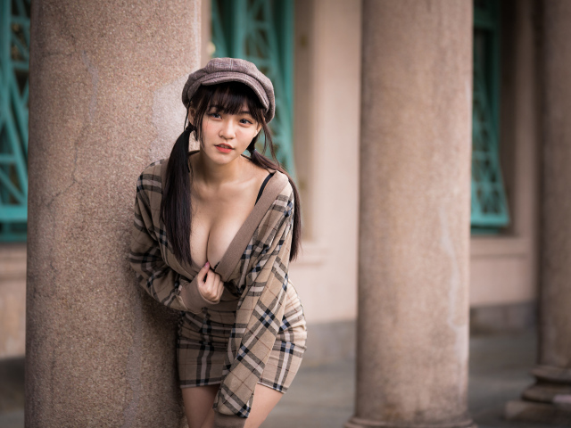 Сексуальная девушка азиатка стоит у колонны 
