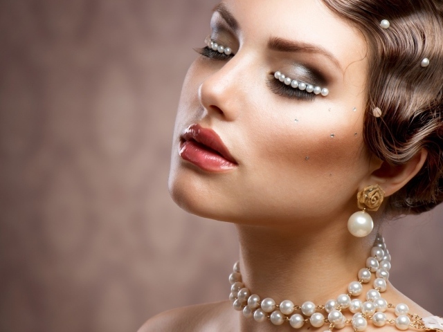 Лицо и тело красивой девушки украшено жемчугом 