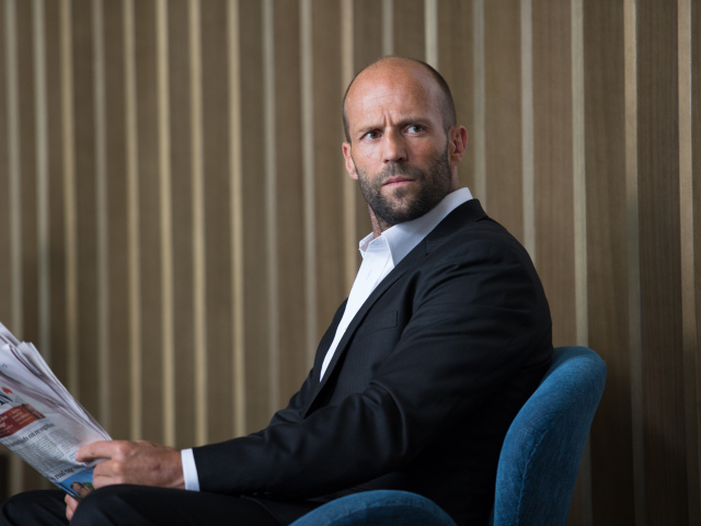 Актер Джейсон Стэтхэм в кресле у стены