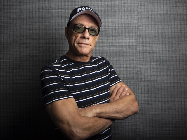 Популярный актер Жан-Клод Ван Дамм в кепке у стены