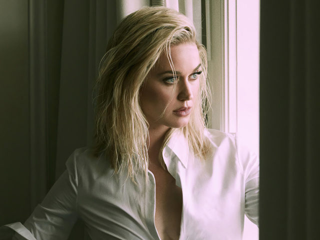 Певица Кэти Перри стоит у окна