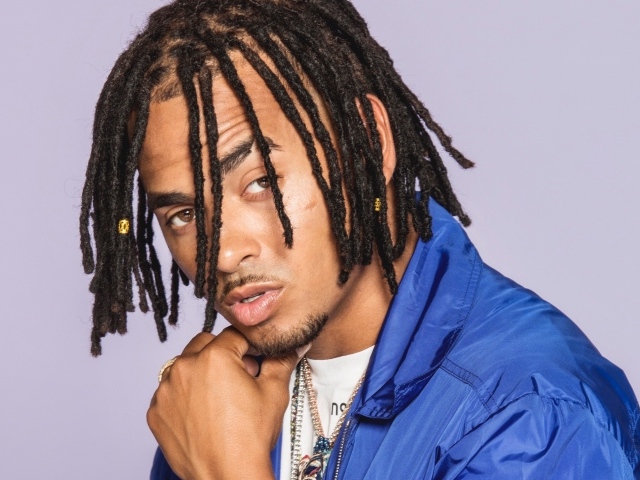 Певец Осуна на сером фоне