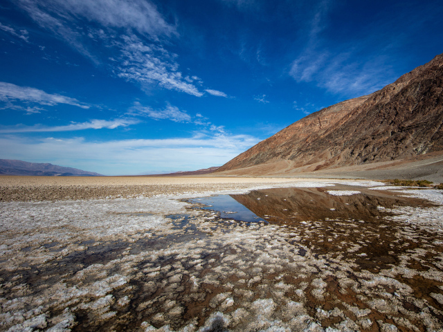 Соленая земля у горы под голубым небом