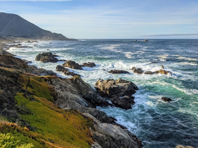 Голубая морская вода омывает камни на берегу 