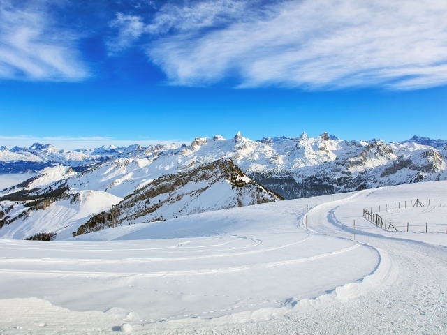 Красивый белый зимний горный пейзаж под голубым небом 