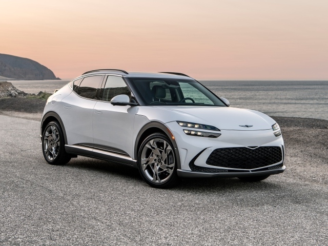 Белый автомобиль Genesis GV60, 2023 года на пляже