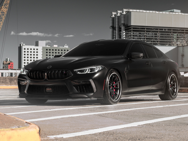 Черный автомобиль BMW M8 на стройке