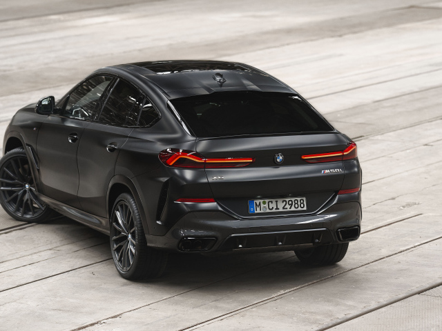 Стильный черный автомобиль BMW X6 M50i, 2023 года вид сзади