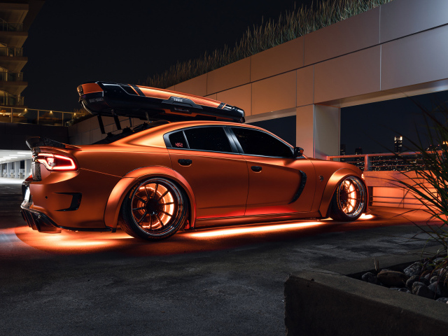 Оранжевый автомобиль Dodge Charger стоит у гаража