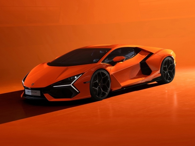 Автомобиль Lamborghini Revuelto 2023 года на оранжевом фоне