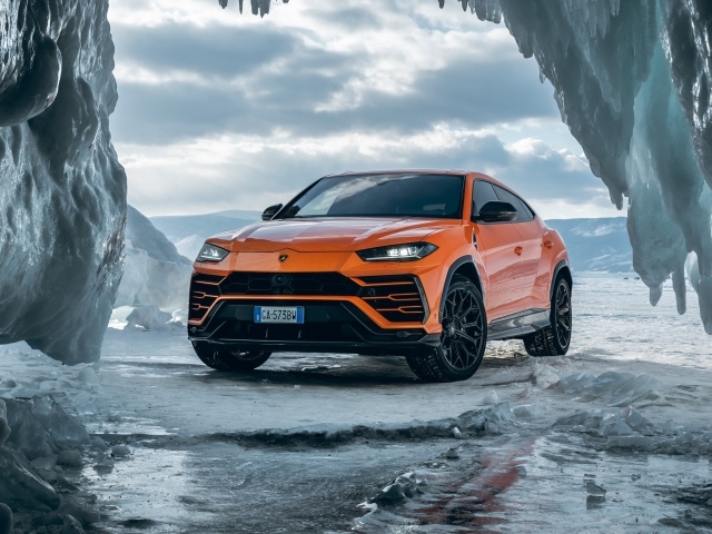 Оранжевый внедорожник Lamborghini Urus у ледяной пещеры