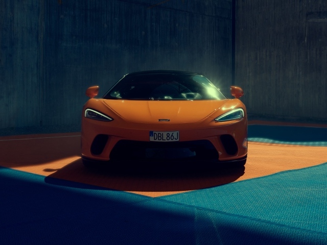 Оранжевый автомобиль McLaren GT вид спереди