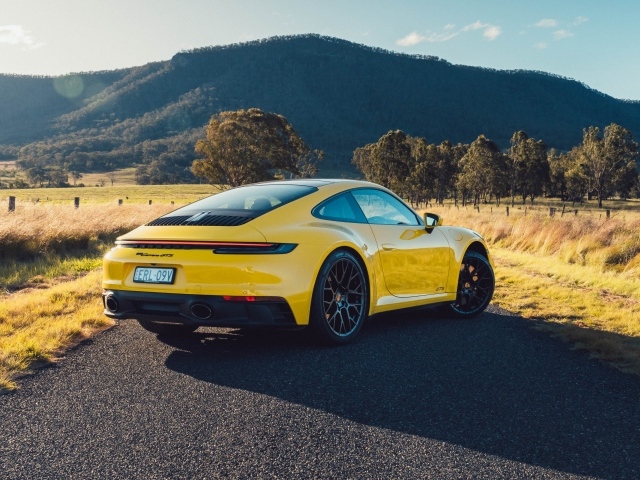 Желтый автомобиль Porsche 911 Carrera GTS вид сзади