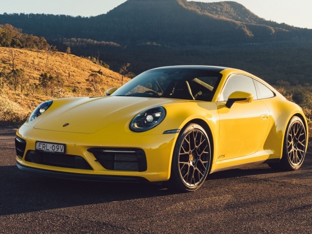 Желтый быстрый автомобиль Porsche 911 Carrera GTS вид спереди