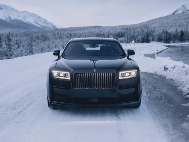 Черный автомобиль Rolls-Royce Black Badge Ghost  на зимней дороге