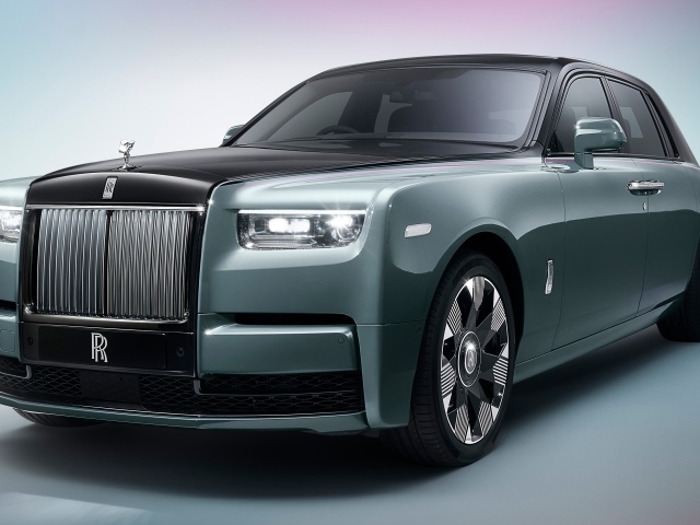 Дорогой автомобиль Rolls-Royce Phantom на сером фоне