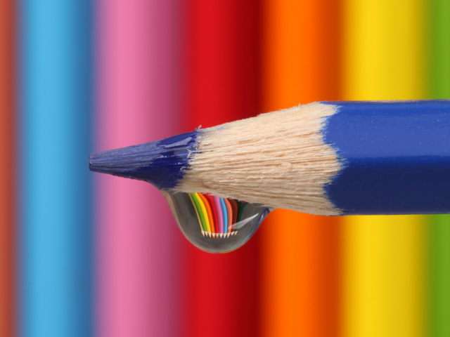 Капля воды стекает с синего карандаша