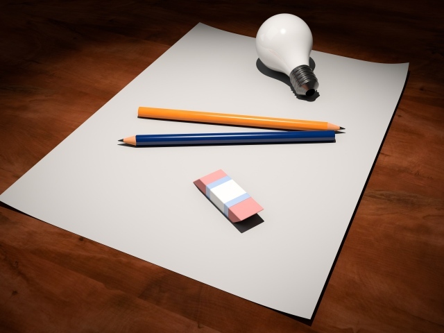 Лист бумаги, карандаши, ластик и лампочка на столе