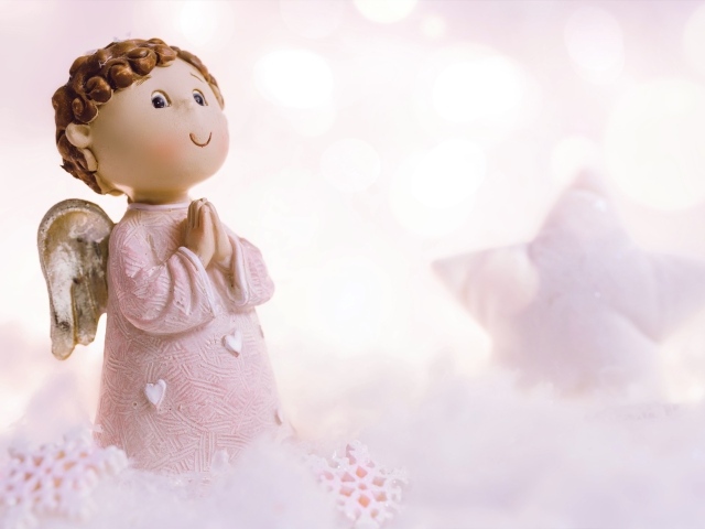 Маленькая статуэтка ангела стоит на снегу