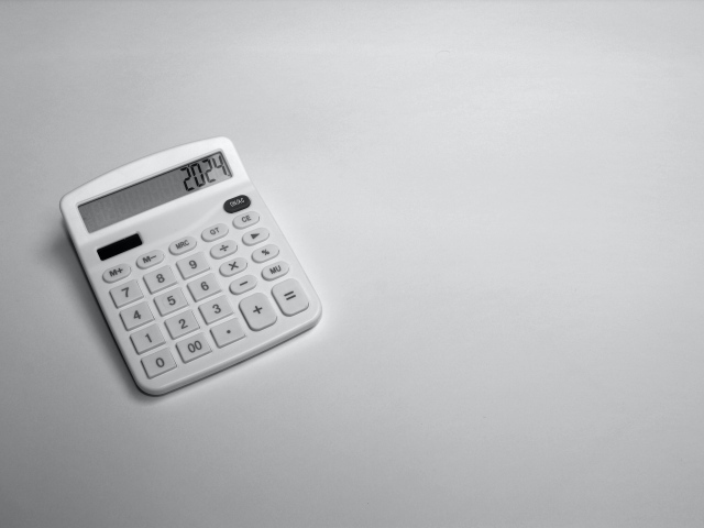 Калькулятор с цифрами 2024 на сером фоне