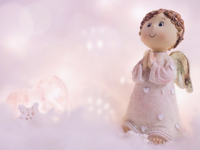 Статуэтка ангела на розовом фоне