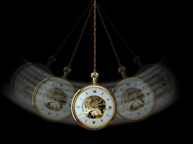 Карманные часы раскачиваются на черном фоне