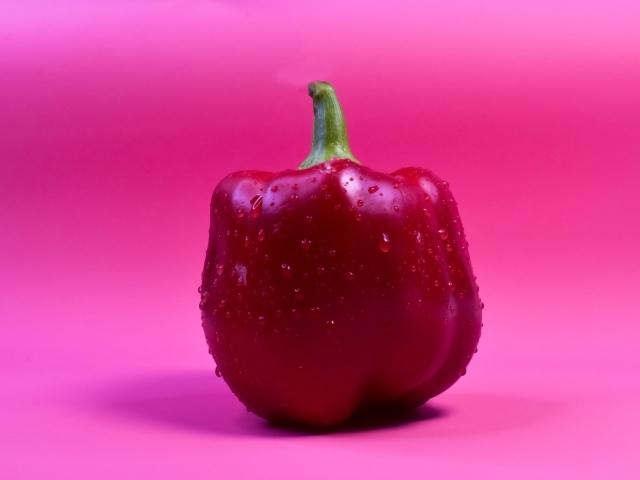 Большой красный перец на розовом фоне