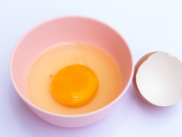 Разбитое яйцо на столе со скорлупой