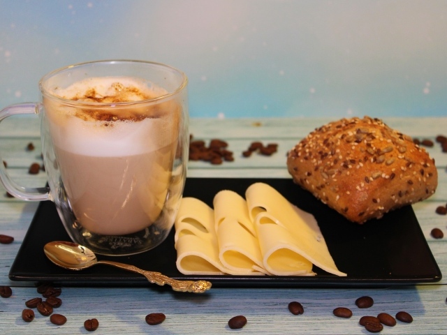 Сыр на тарелке с какао и булочкой