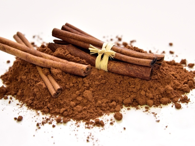 Корица с порошком на белом фоне 