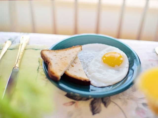 Яичница с хлебом на столе на завтрак 