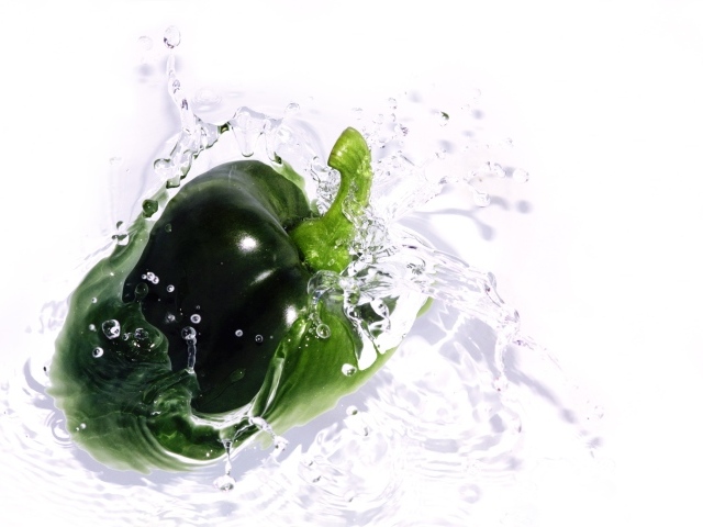 Зеленый перец в воде на белом фоне