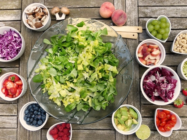 Зеленый салат на столе с ягодами и овощами