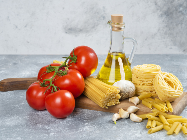 Паста, помидоры и масло на столе