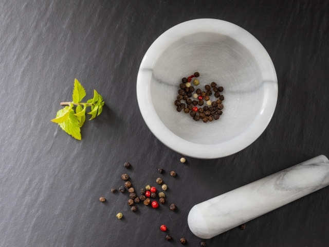 Перец горошком в ступе на сером столе