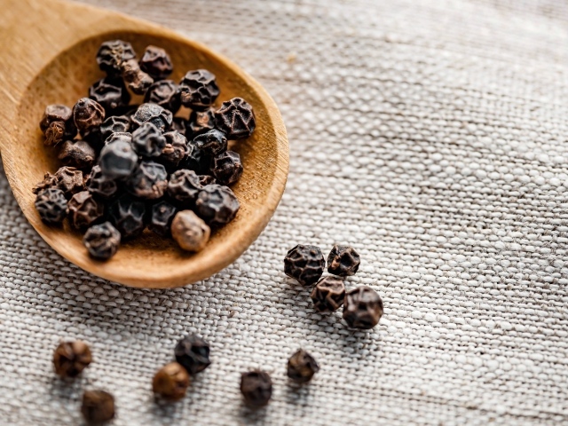 Перец горошком на деревянной ложке