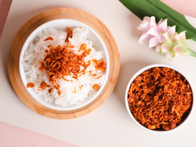 Рис с луком на столе с цветком
