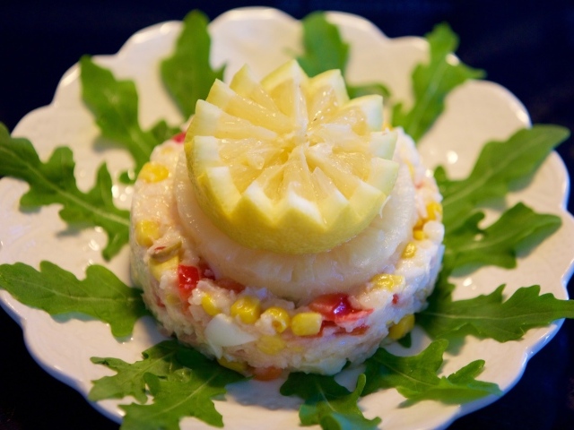 Салат на тарелке с лимоном и рукколой
