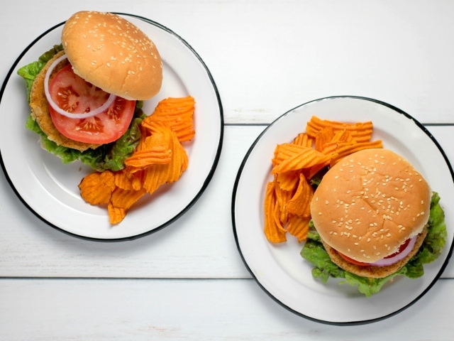 Два гамбургера на тарелке с чипсами