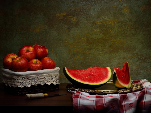 Скибки арбуза на столе с яблоками 