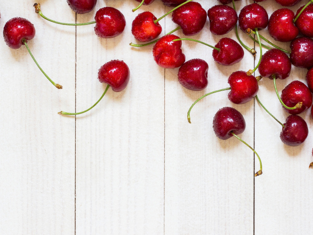 Аппетитные свежие красные ягоды черешни на белом столе
