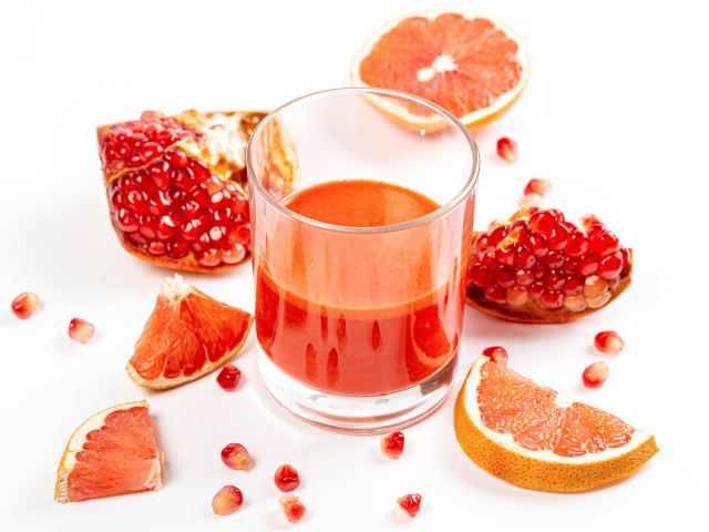 Грейпфрут и гранат на столе с соком