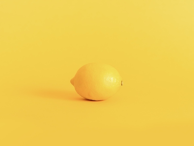 Большой желтый лимон на желтом фоне