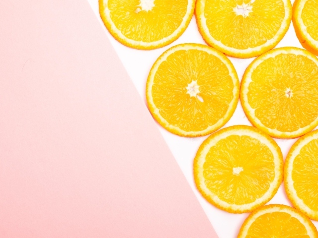 Кружочки апельсина на розовом фоне