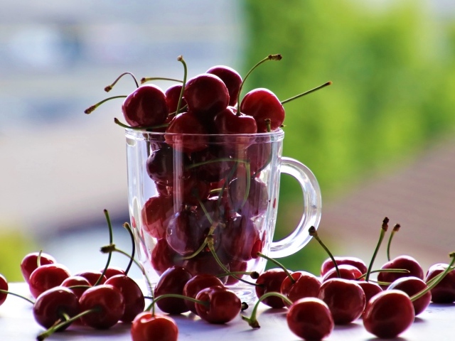 Красные черешни в стеклянной чашке 