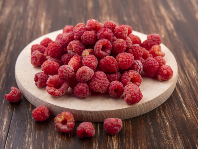 Спелая красная малина на доске