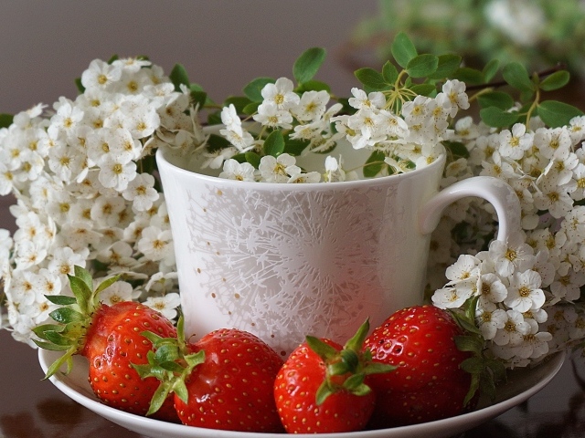 Клубника на тарелке с чашкой и белыми цветами